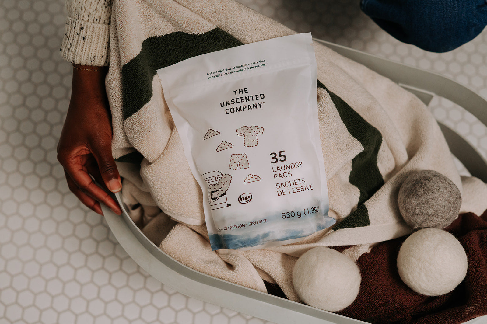 A bright, modern laundry room featuring eco-friendly laundry products, wool dryer balls, and clothes air-drying on a wooden rack.