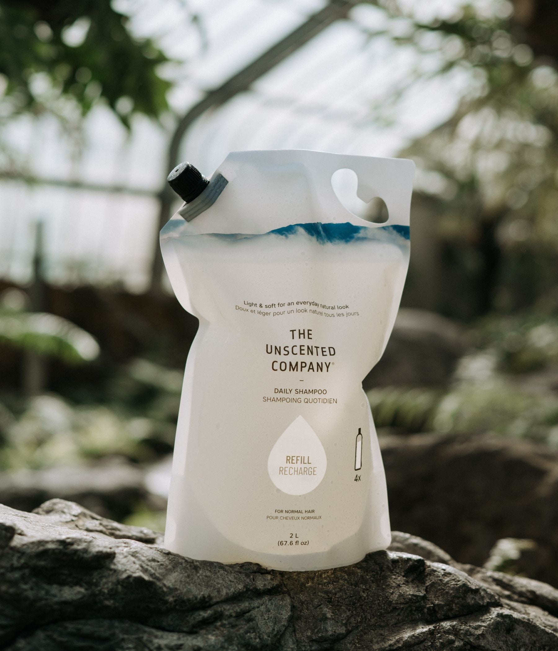 Shampoo refill pouch from The Unscented Company placed on a rock.