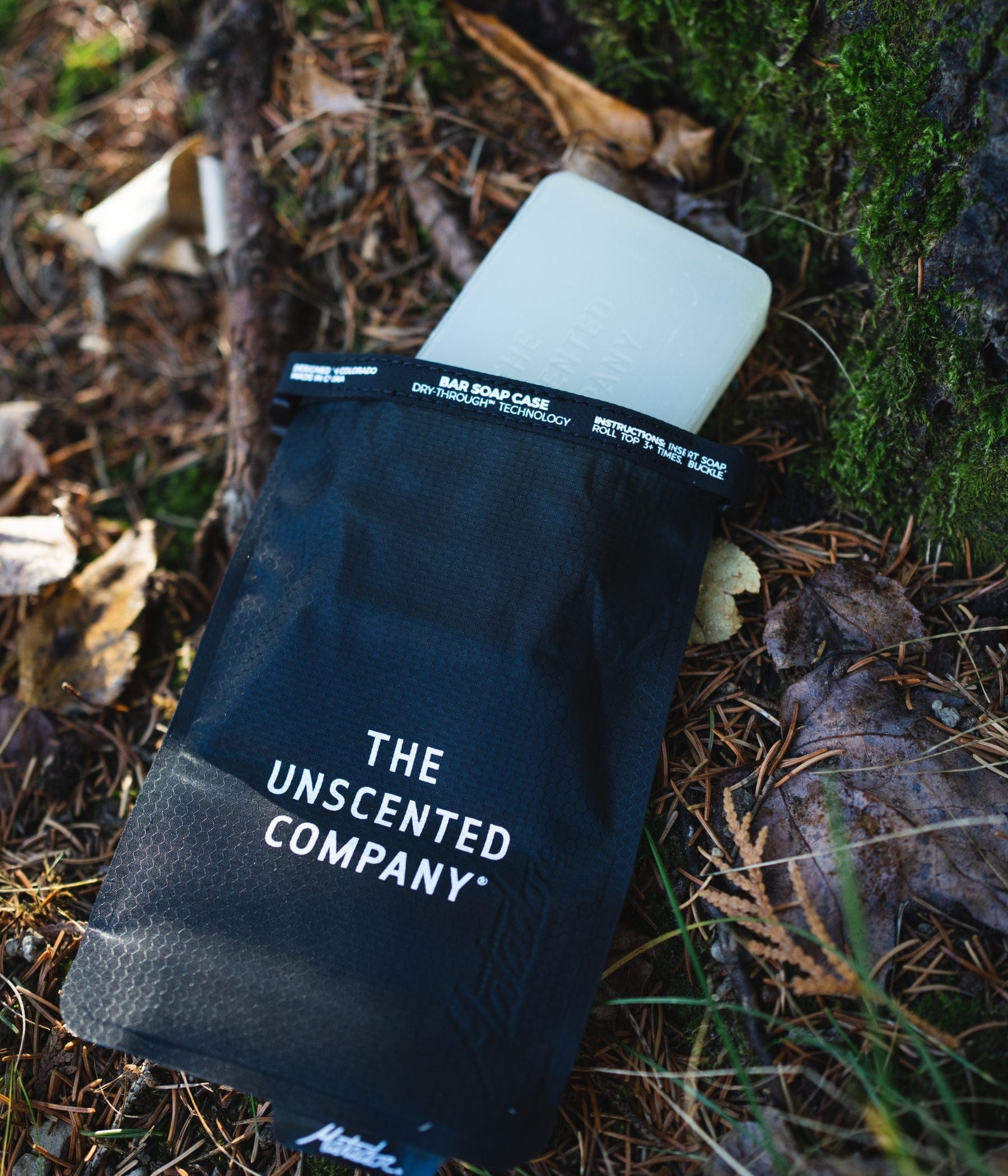 A soap bar in a black pouch on the forest floor.