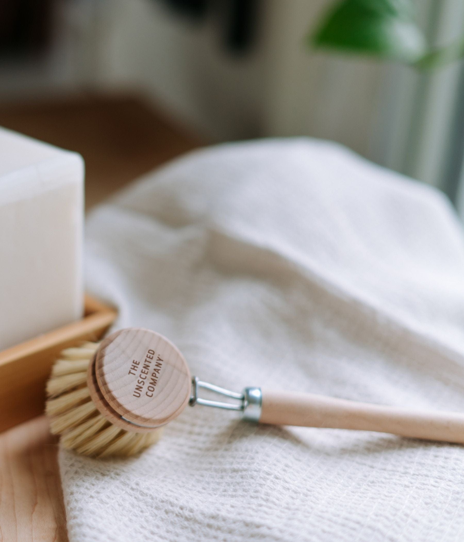 Wooden dish brush on a white cloth.
