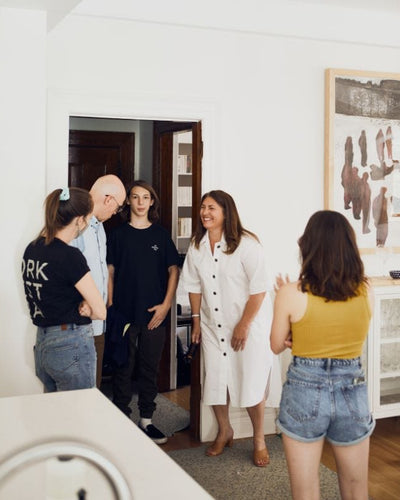 Group of people talking and smiling inside a home.