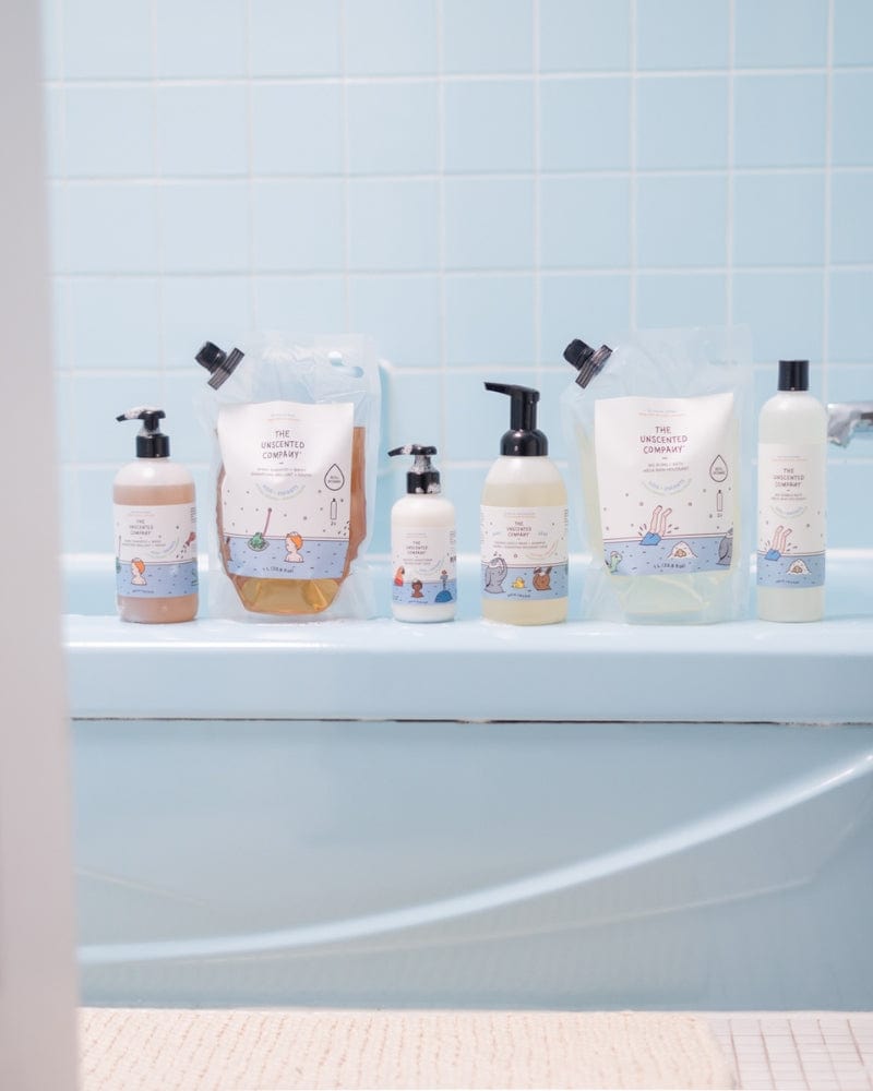 Kids' bath products from The Unscented Company on a blue bathtub.