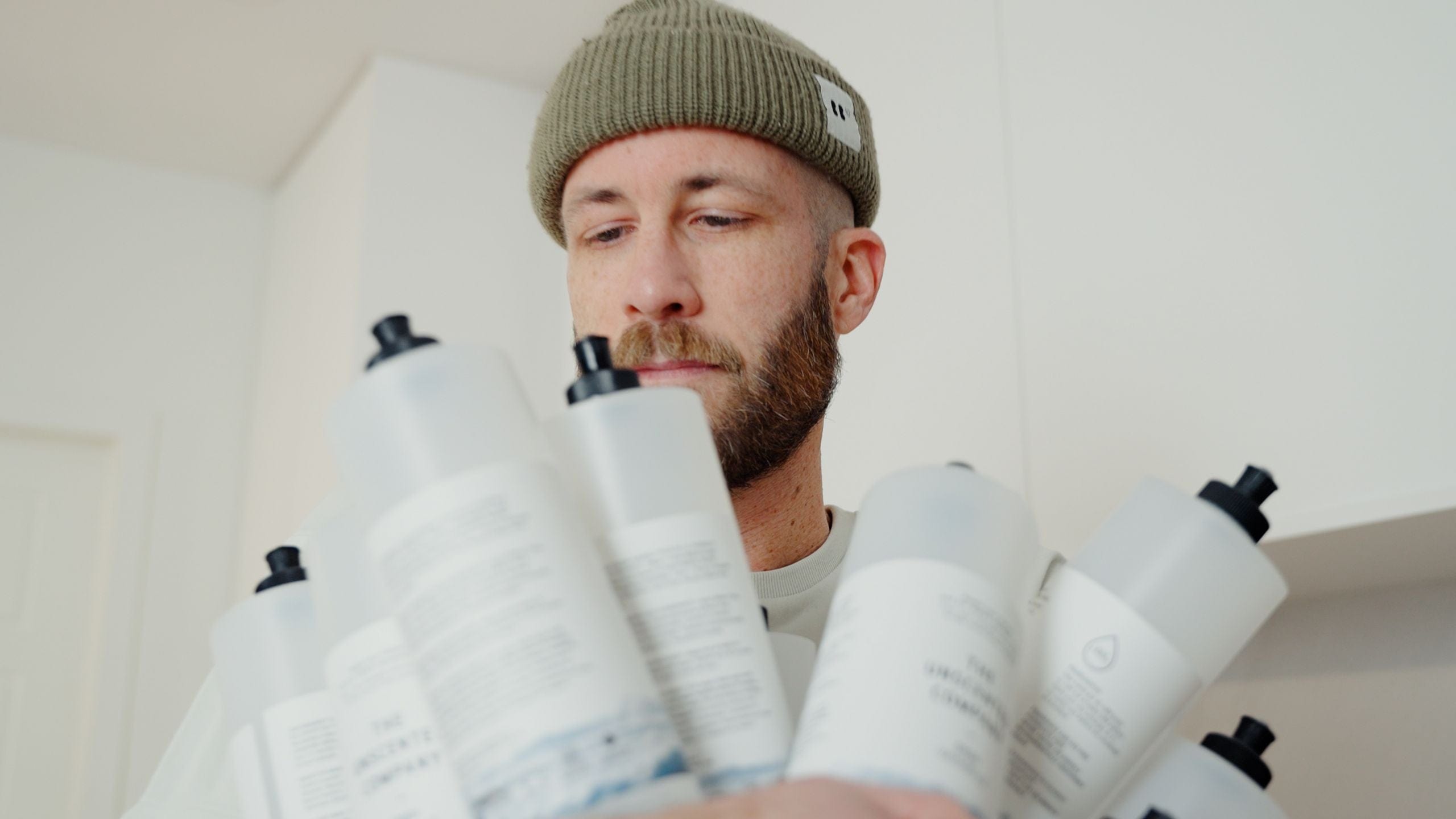 Man holding multiple refill bottles of The Unscented Company.