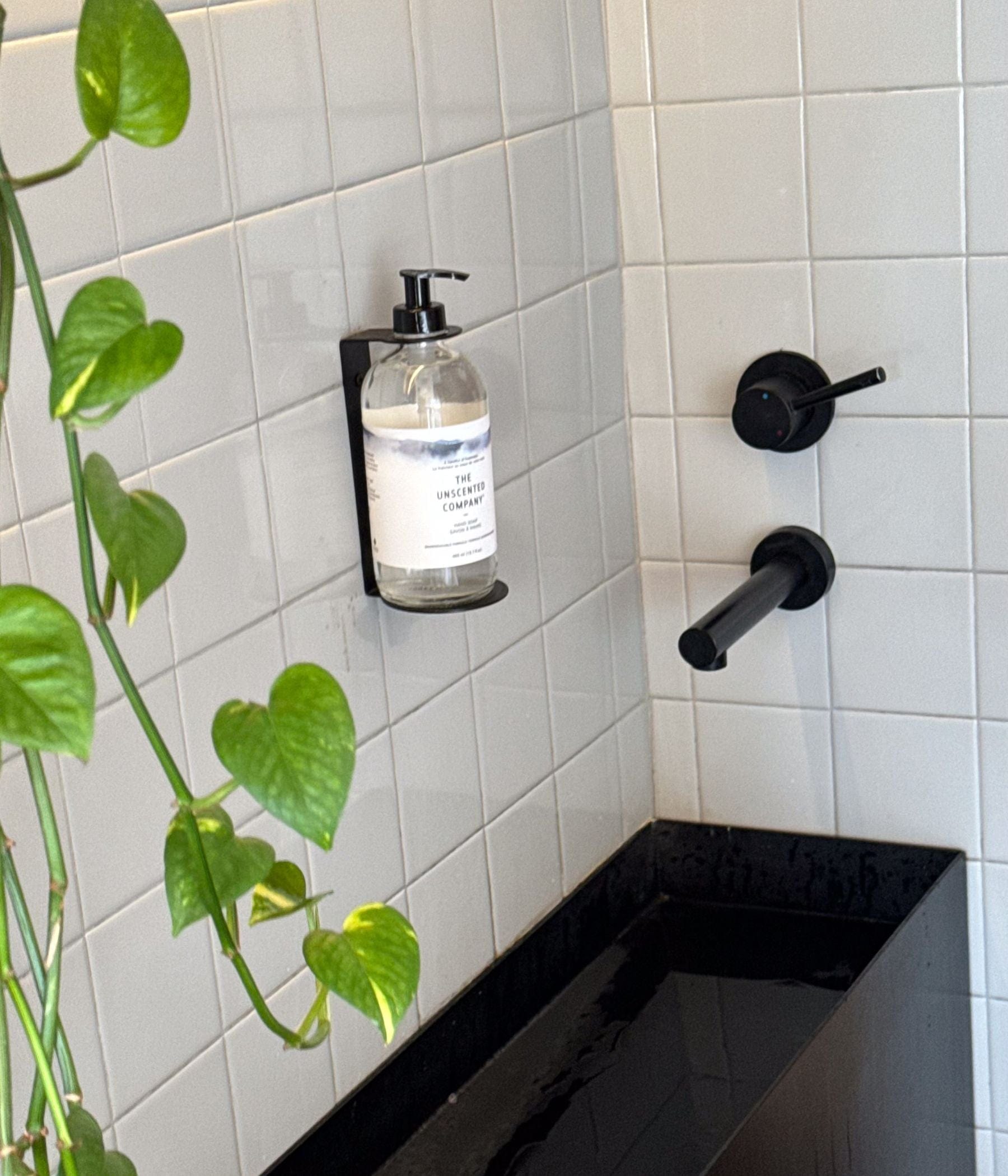 The Unscented Company hand soap in a wall-mounted pump bottle by a sink