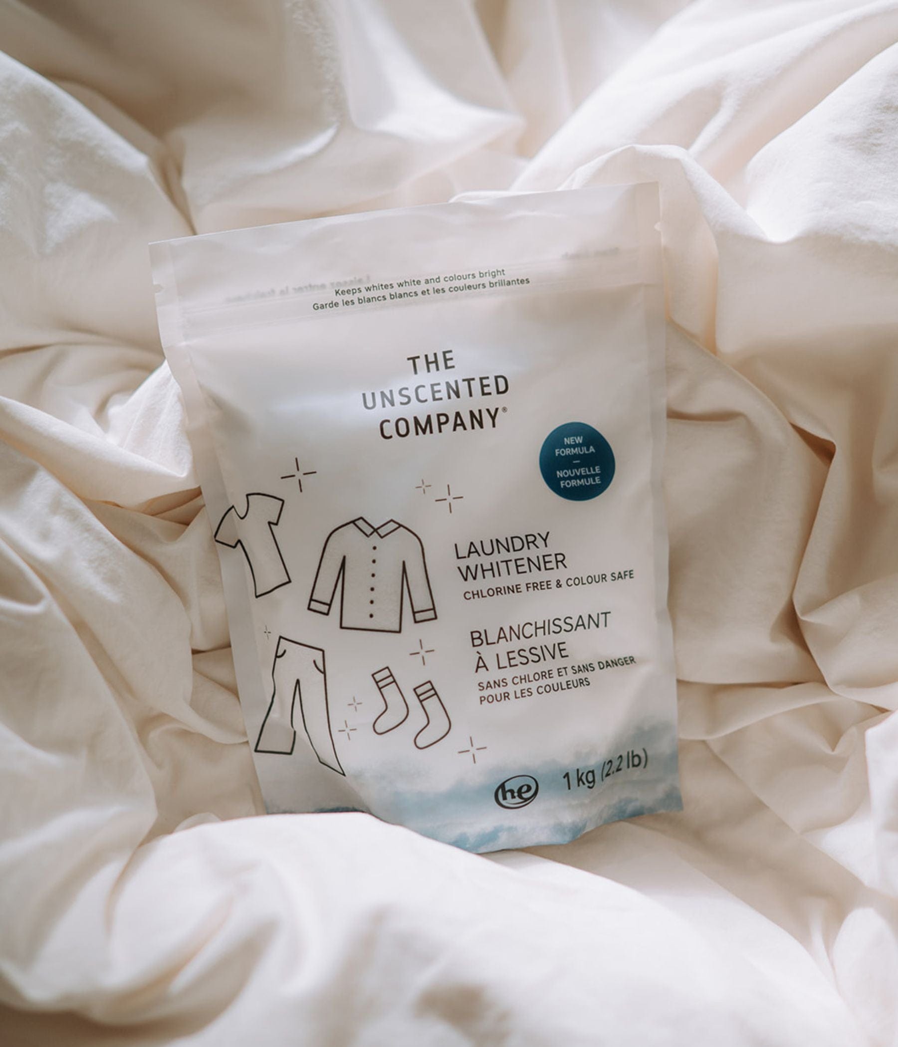 The Unscented Company Laundry Whitener 1 kg bag on white fabric. Text on the package says chlorine free and colour safe.