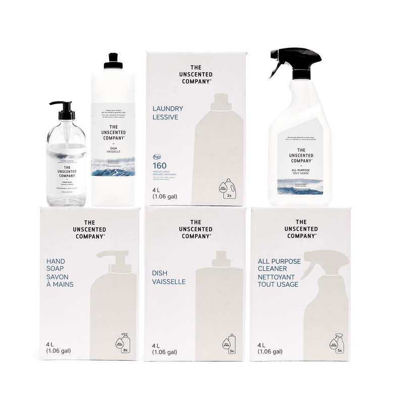 A collection of eco-friendly cleaning products from The Unscented Company, including large 4L refill boxes of hand soap, dish soap, all-purpose cleaner, and laundry detergent, alongside a spray bottle, a pump bottle, and a laundry jug.