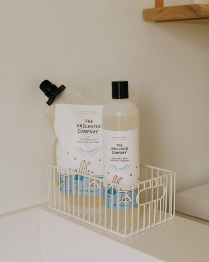 Bottle and package of 'The Unscented Company' bubble bath on a white shelf.