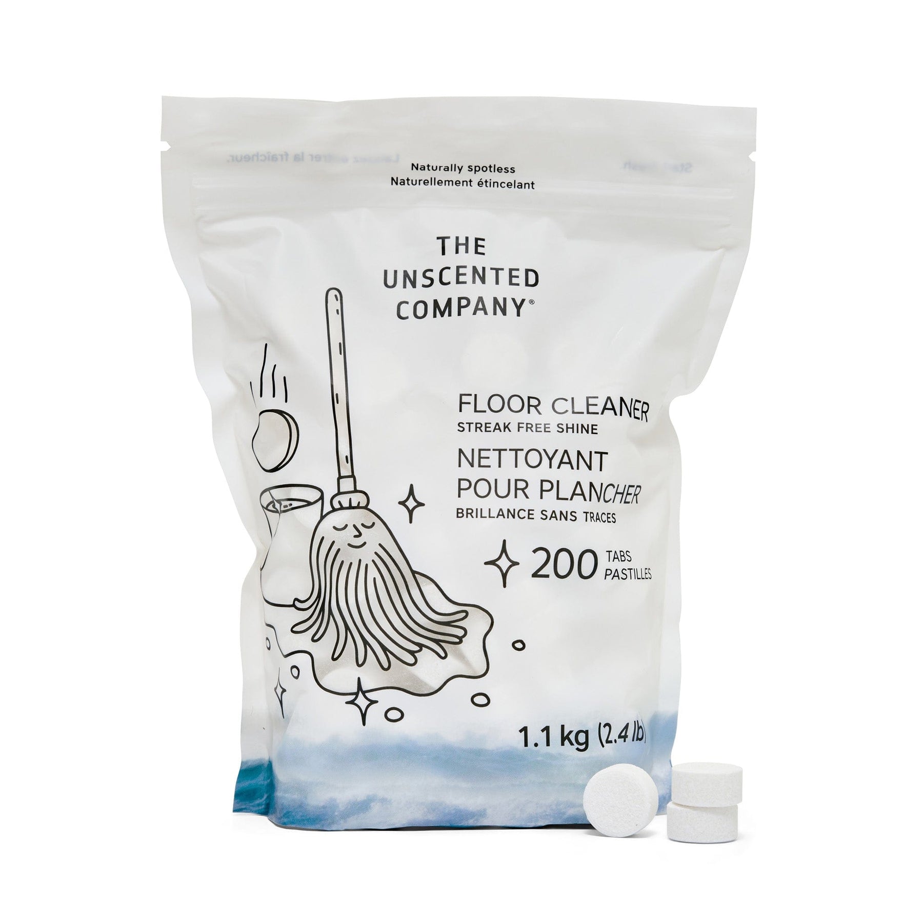 A pouch of The Unscented Company Floor Cleaner with a cheerful mop illustration, labeled in English and French, indicating 200 biodegradable tablets and a weight of 1.1 kg (2.4 lb), with three white cleaning tabs placed in front of the package.