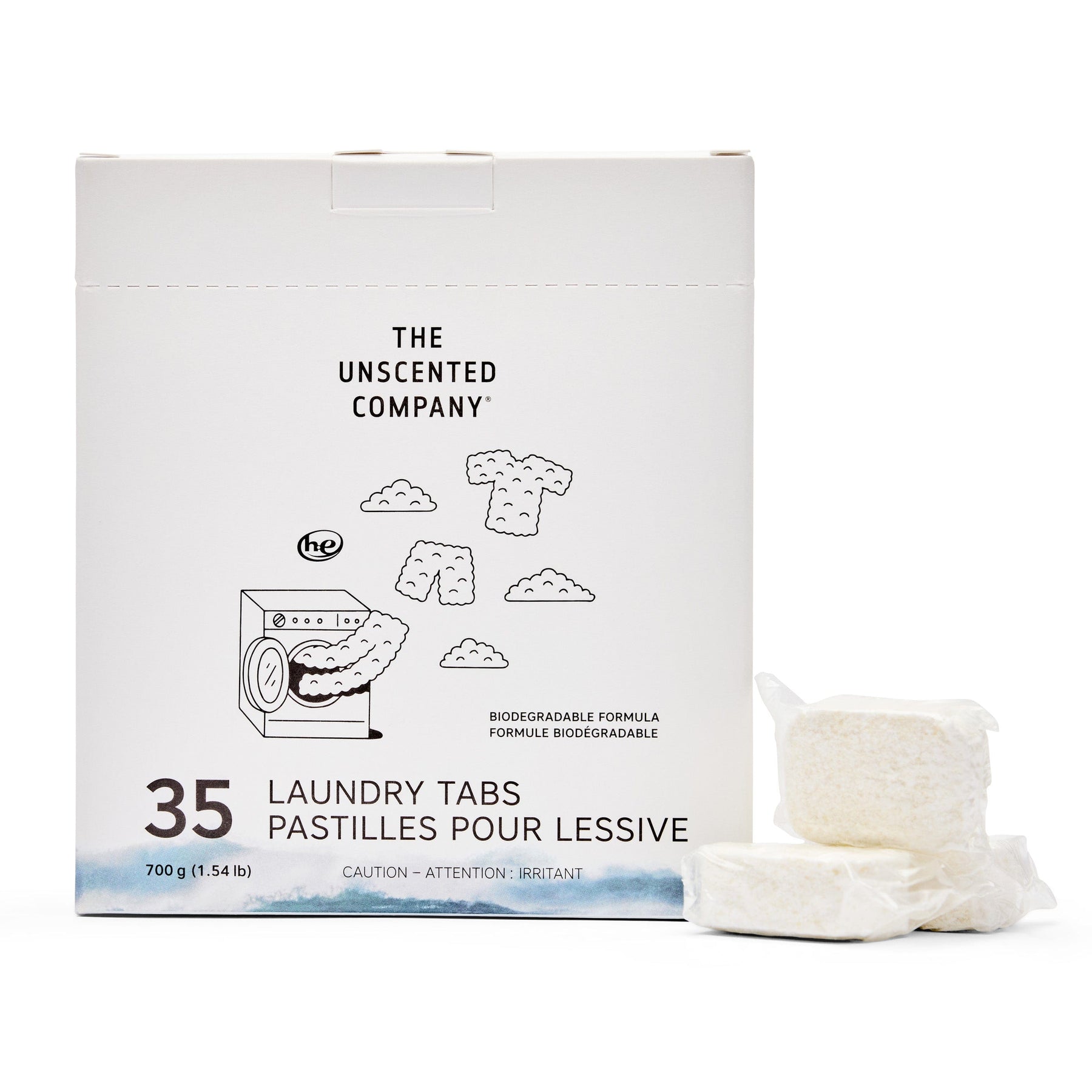 Front of The Unscented Company laundry tabs box (35 count). Shows product name, weight, biodegradable formula claim, and illustration of a washer with floating clothes. Two unwrapped tabs placed beside the box.