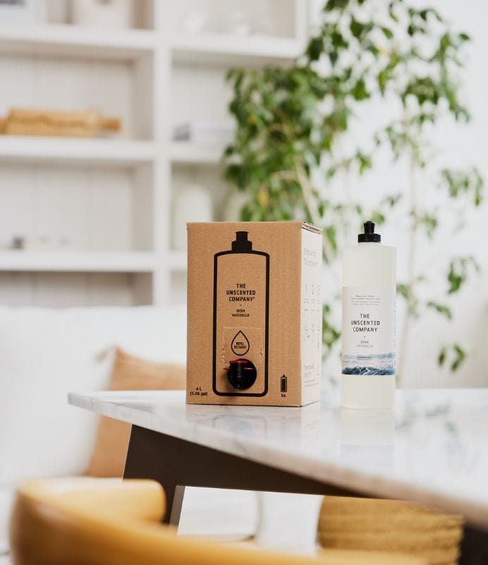 The Unscented Company dish soap and refill box on a bright kitchen table