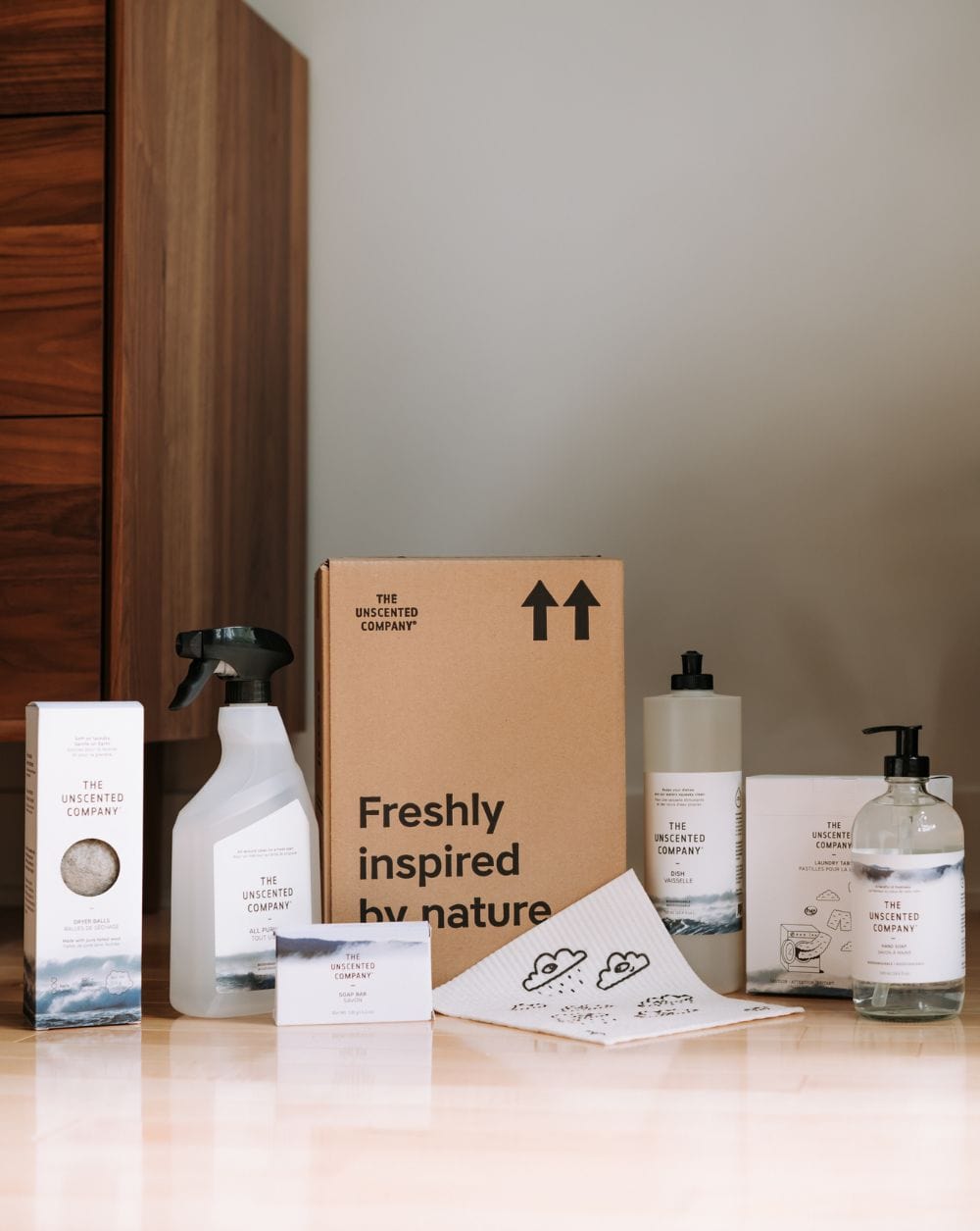 Selection of The Unscented Company cleaning essentials arranged beside a branded box.