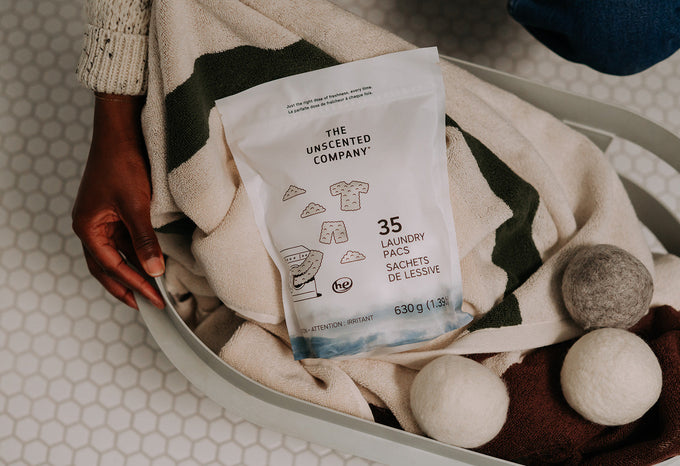 A bright, modern laundry room featuring eco-friendly laundry products, wool dryer balls, and clothes air-drying on a wooden rack.