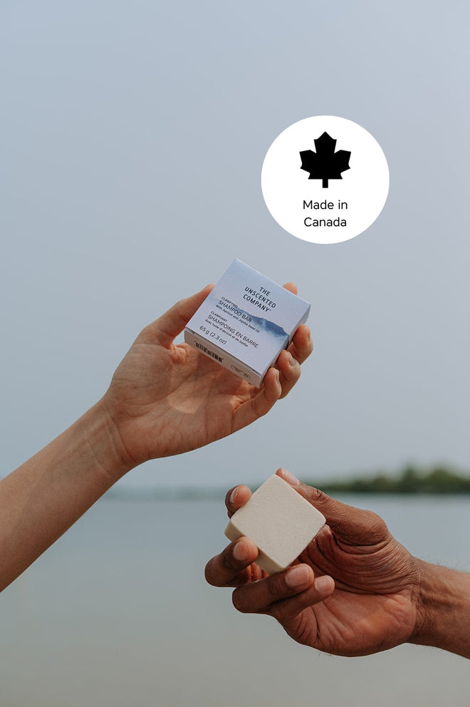 Hands holding a The Unscented Company shampoo bar with a “Made in Canada” icon.