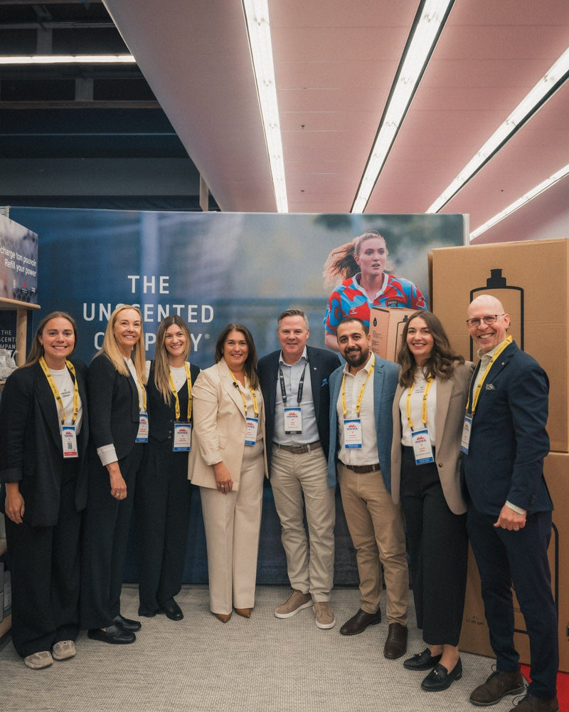 Anie Rouleau, founder of The Unscented Company, posing with Greg Hicks, President and CEO of Canadian Tire, alongside team members at a trade show booth featuring the brand’s sustainable household products.
FR :
Anie Rouleau, fondatrice de The Unscented Company, posant avec Greg Hicks, président et chef de la direction de Canadian Tire, accompagnés de membres de l’équipe devant un kiosque présentant les produits ménagers durables de la marque.

If you want, I can also show you a slightly stronger SEO versio
