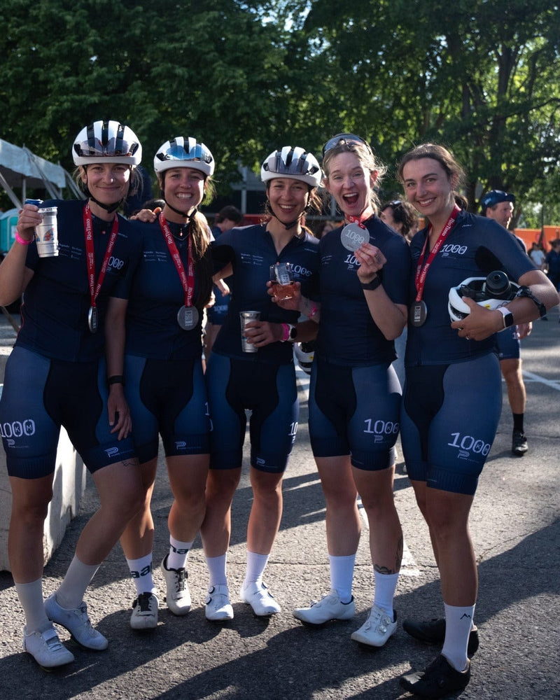 Group of cyclists celebrating after a race while wearing medals and team jerseys, highlighting community, endurance, and the active lifestyle supported by The Unscented Company.
