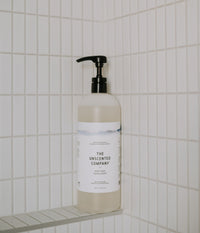 The Body Soap - 1L placed in the corner of a shower ledge.