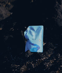 A 1L light refill pouch of The Unscented Company Hydrating Conditioner set against dark coastal rocks