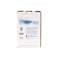 Back view of The Unscented Company 4 L hand soap box with ingredient list, safety instructions, Women Owned certification, and blue landscape graphic on minimalist white eco-friendly packaging.
