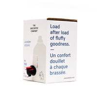 Side view of The Unscented Company 4 L laundry detergent box with dispenser tap, featuring the text “Load after load of fluffy goodness,” on minimalist white eco-friendly packaging.